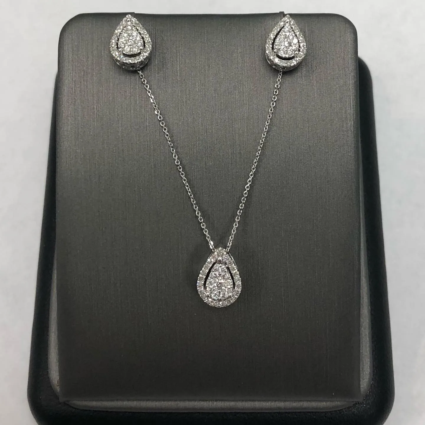 Diamond teardrop pendant with matching halo stud earrings, handcrafted at Goss Company Jewelers